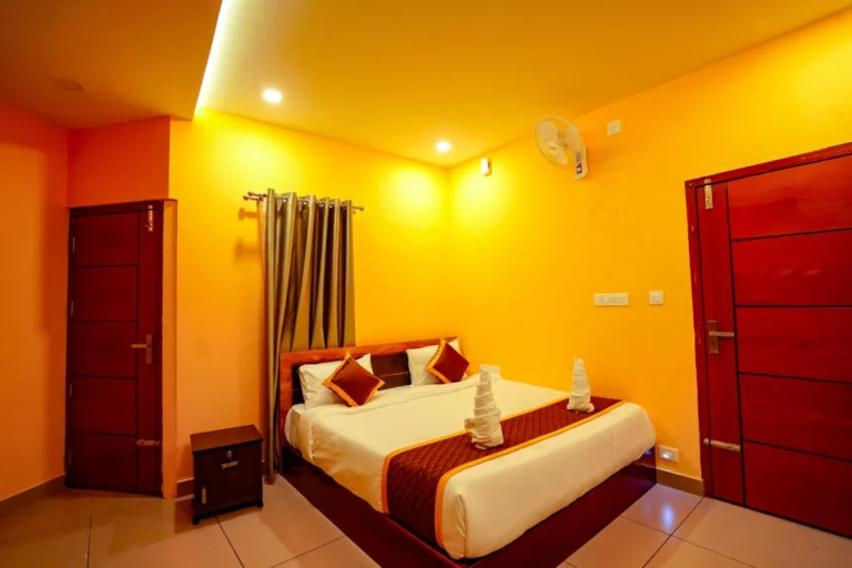 Elegant king-size bedroom with warm lighting, modern décor, and cozy ambiance at the best resort in Wayanad.