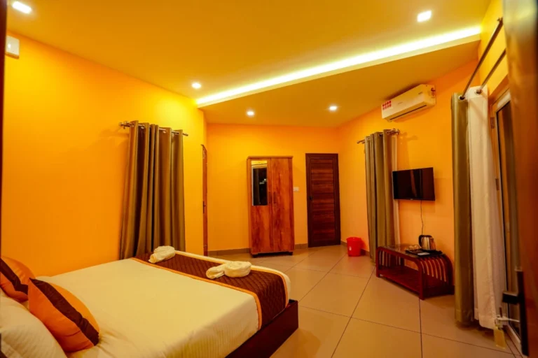 Modern air-conditioned luxury room with cozy king-size bed, TV, and elegant interiors at the best resort in Wayanad.